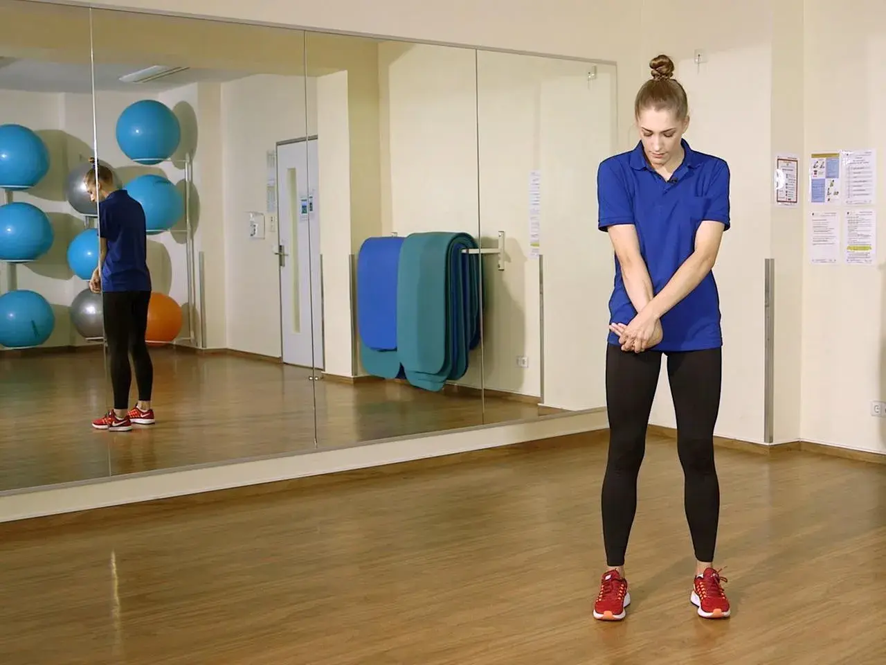 Frau dehnt ihre Arme und Ellenbogen in einem Fitnessstudio.