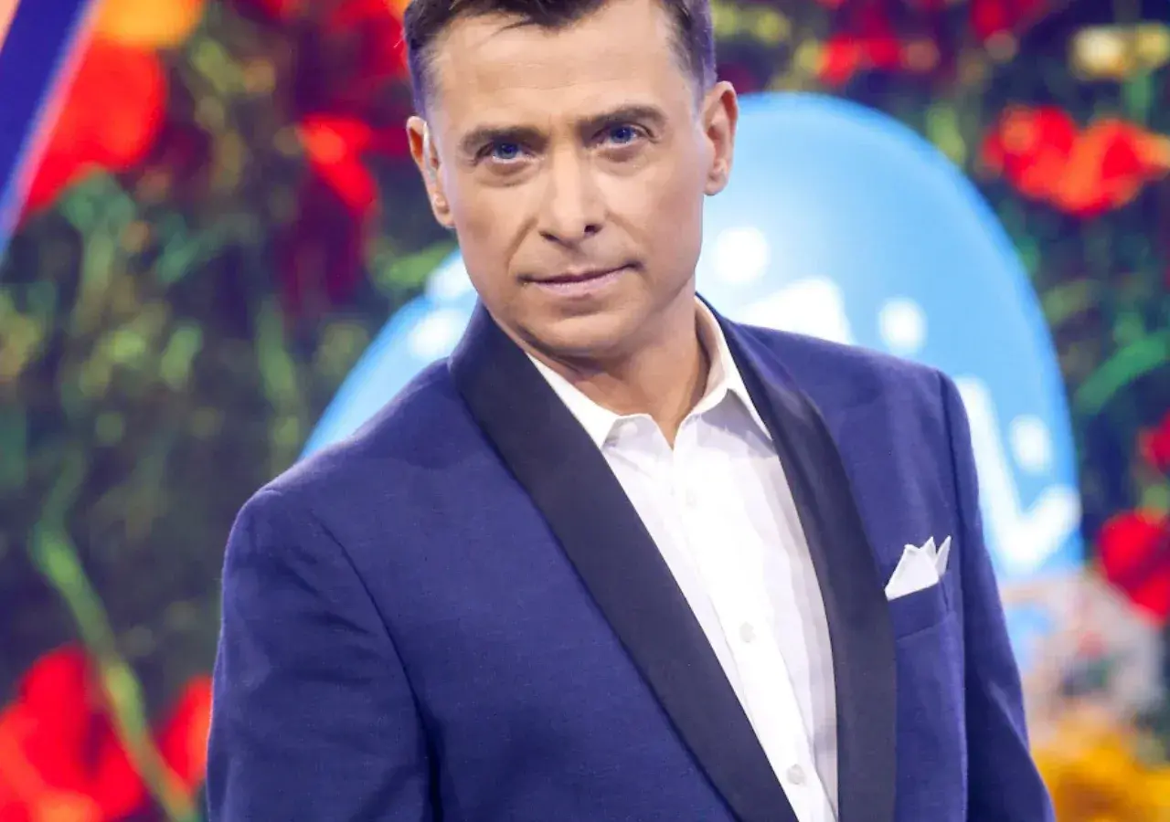 Kacper Kuszewski w granatowej marynarce z czarnym wyłogiem i białą koszulą.