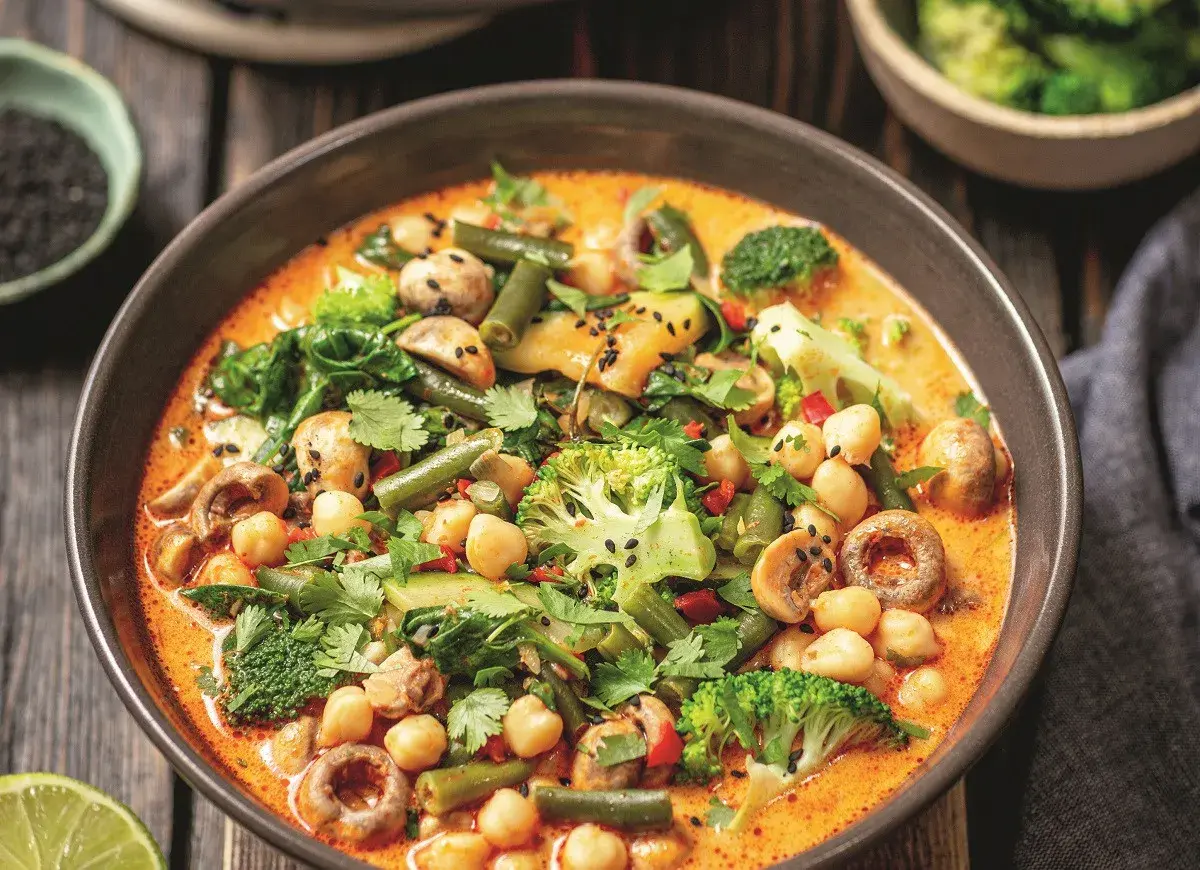 Aksamitne curry z ciecierzycy z brokułami, fasolką szparagową i grzybami, posypane czarnym sezamem.
