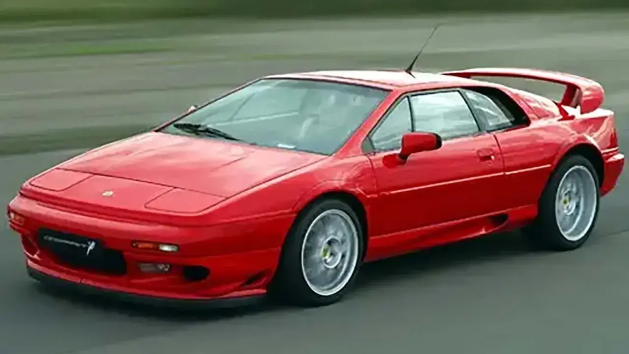 Röd Lotus Esprit, ett ikoniskt sportbilmärke, kör på en asfalterad väg.