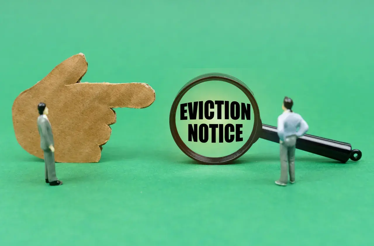 Dito un dito di cartone indica una lente d'ingrandimento con la scritta "EVICTION NOTICE". Un omino guarda la lente, suggerendo un imminente sfratto per finita locazione e canoni non pagati.