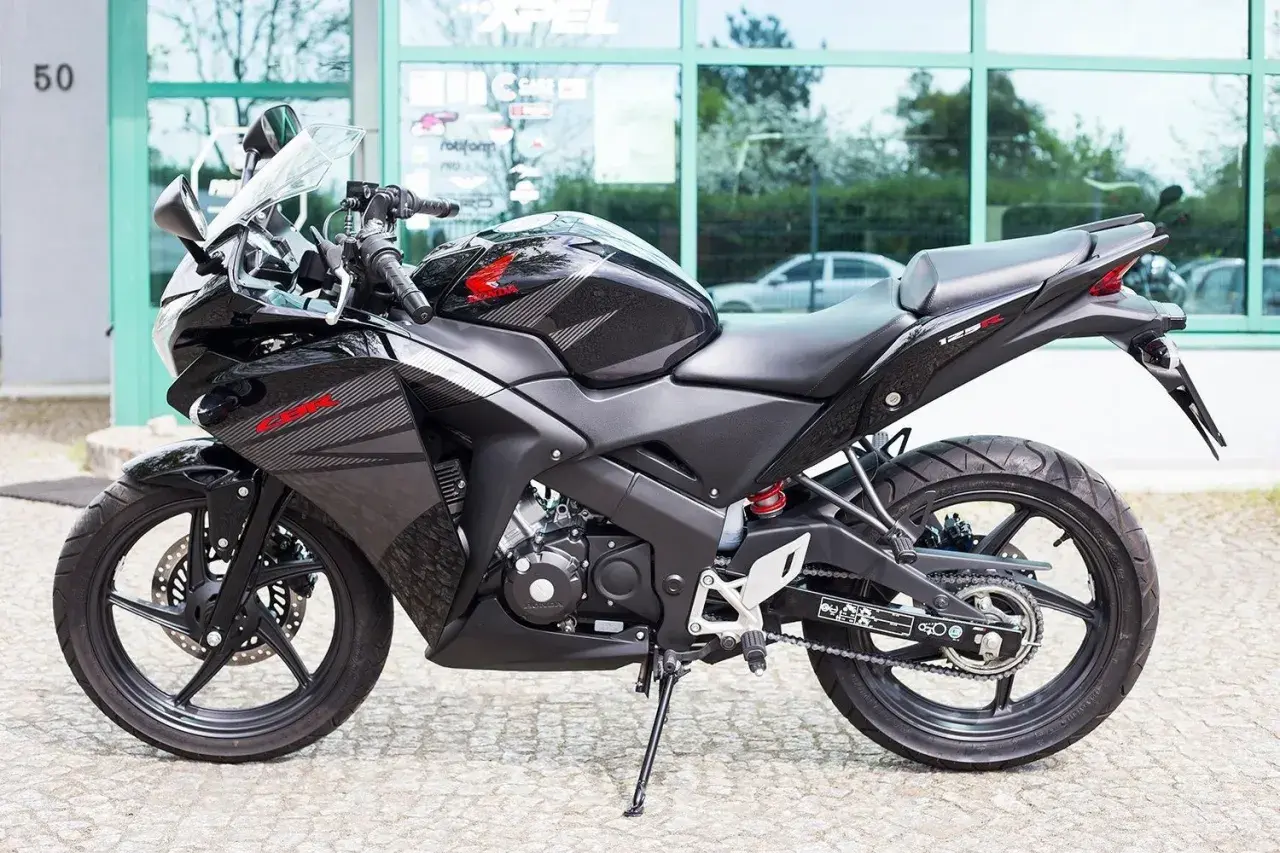 Czarny motocykl Honda CBR 125R z automatyczną skrzynią biegów, gotowy do jazdy po mieście.