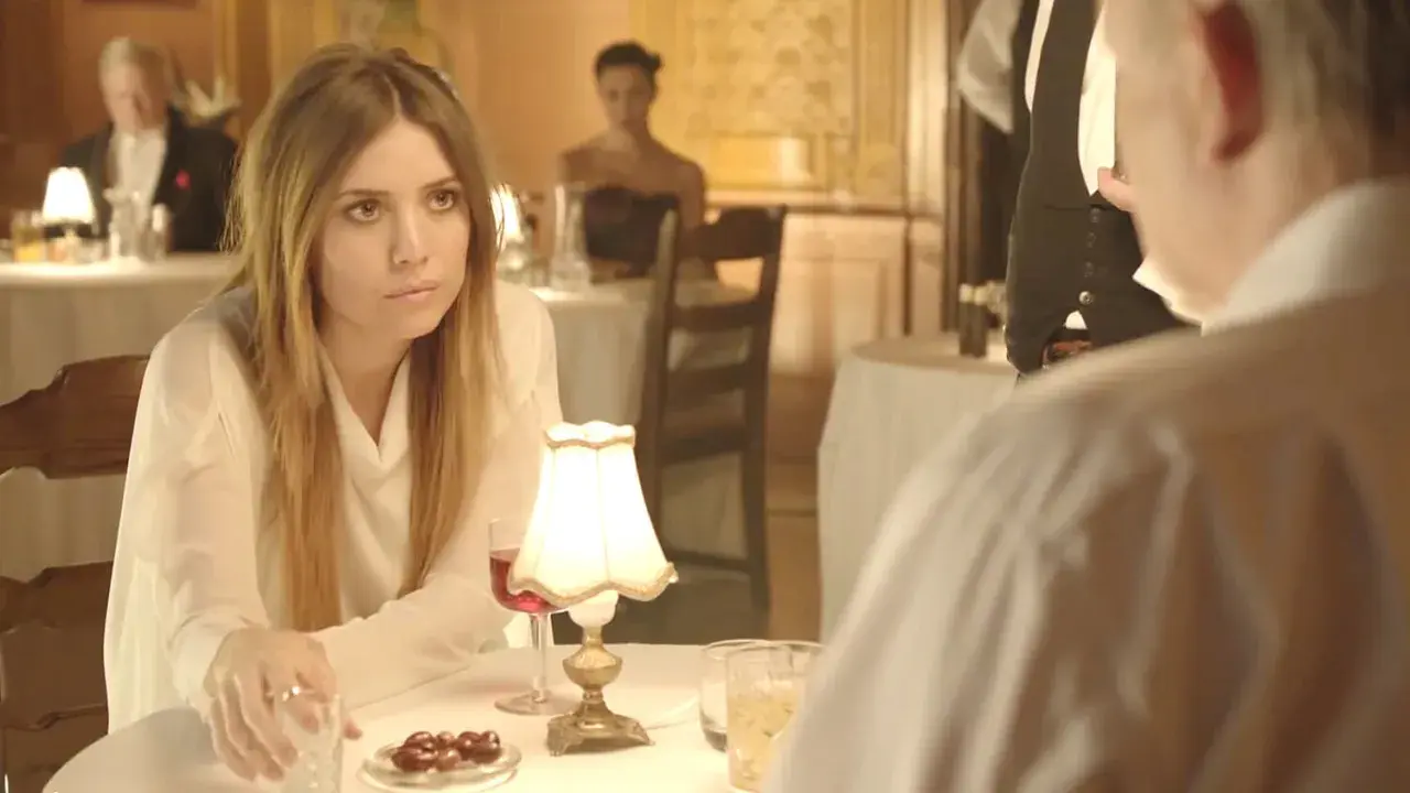 Lykke Li w białej bluzce, zamyślona przy stoliku. Czyżby "sadness is a blessing"?