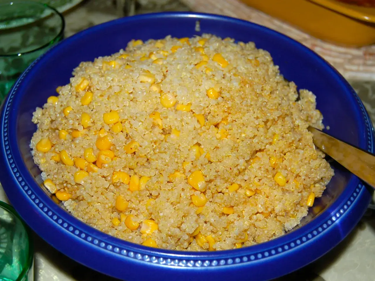 En blå skål fylld med fluffig quinoa och söta majskorn. Perfekt för att koka quinoa till en hälsosam måltid.