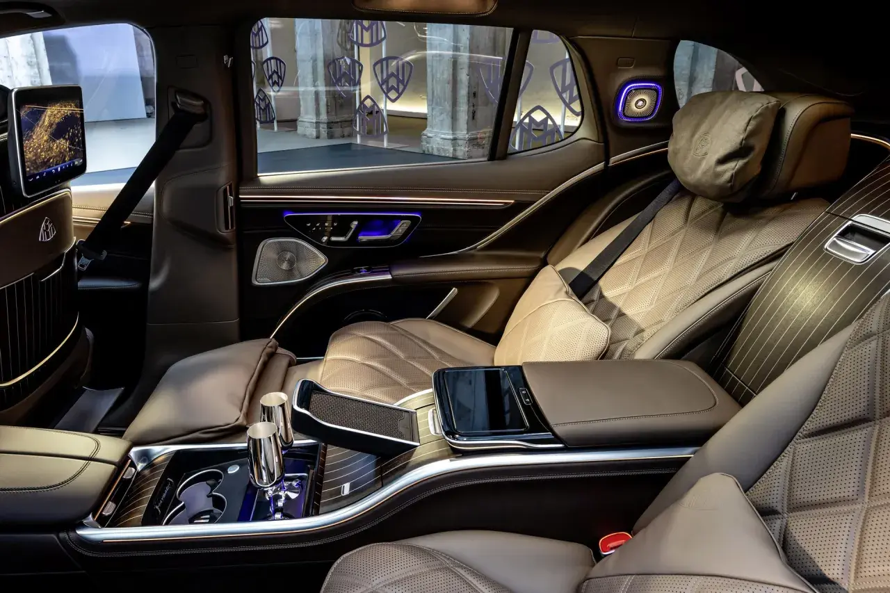 Luksusowe wnętrze Maybach SUV z brązową, pikowaną skórą, ekranami i ambientowym oświetleniem.
