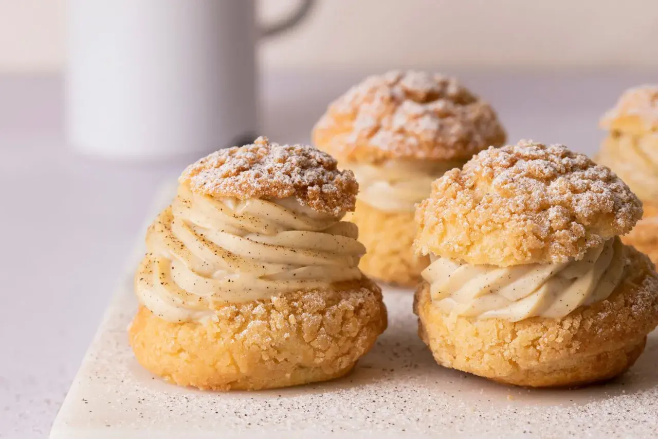 Trois délicieux choux garnis de crème pâtissière à la vanille, saupoudrés de sucre glace. Un vrai plaisir gourmand à base de pâte à choux.