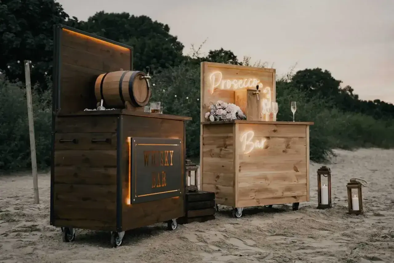 Drewniane bary na wesele: jeden z beczką whisky, drugi z napisem "Prosecco Bar". Idealne na letnie przyjęcie.