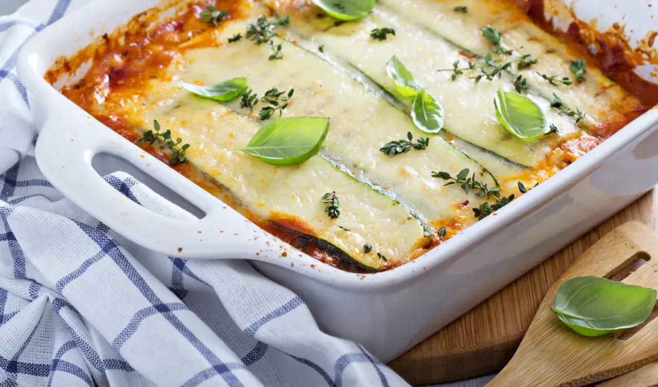 Lasagne aux légumes d'hiver, gratinée et garnie de basilic frais. Un plat réconfortant pour les journées froides.