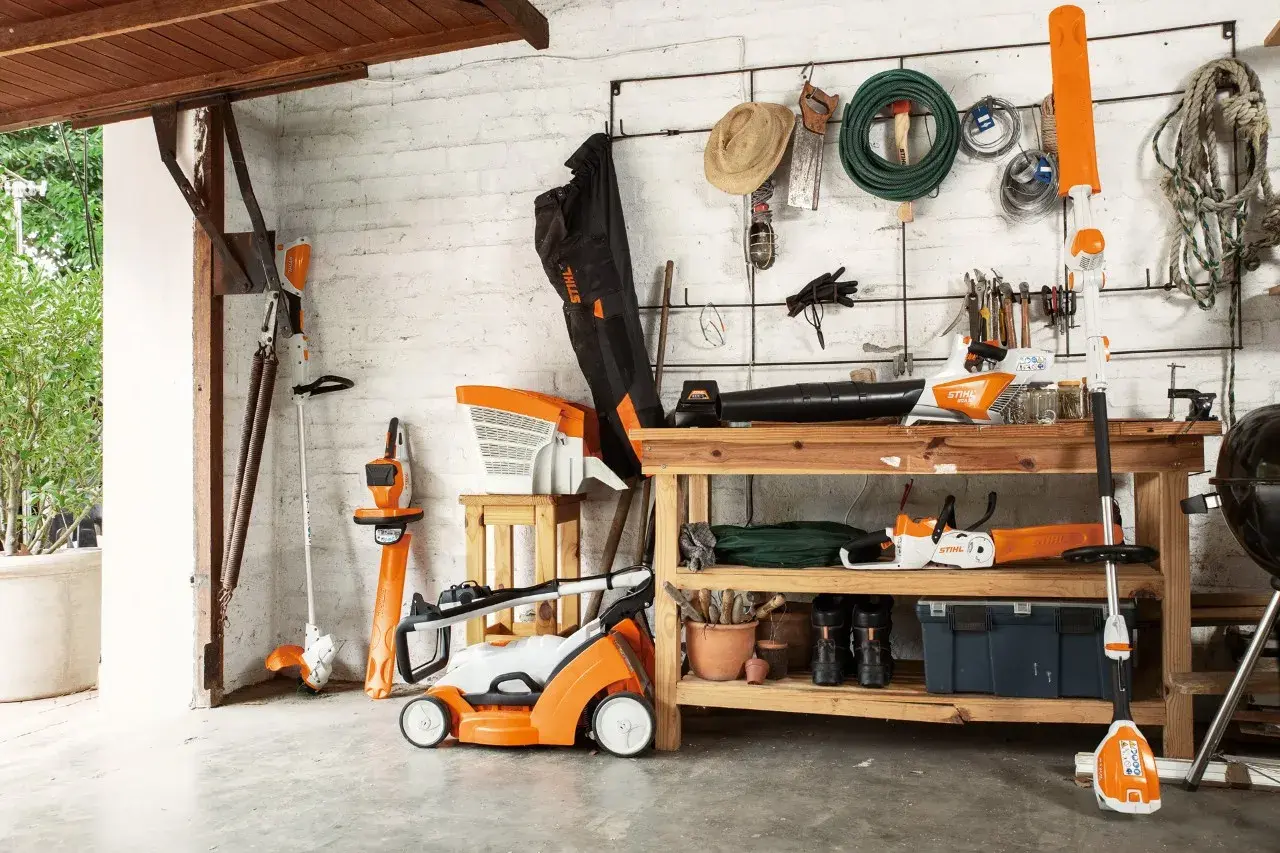 Herramientas de jardín Stihl, incluyendo cómo colgar una desbrozadora en la pared. Todo organizado en un cobertizo.