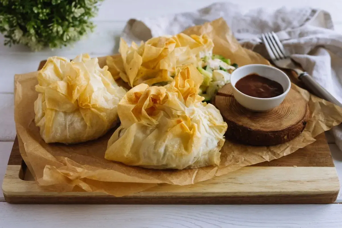 Deliciosos paquetes dorados de pasta filo, crujientes y ligeros, que envuelven un relleno sabroso. Perfectos para cualquier ocasión.