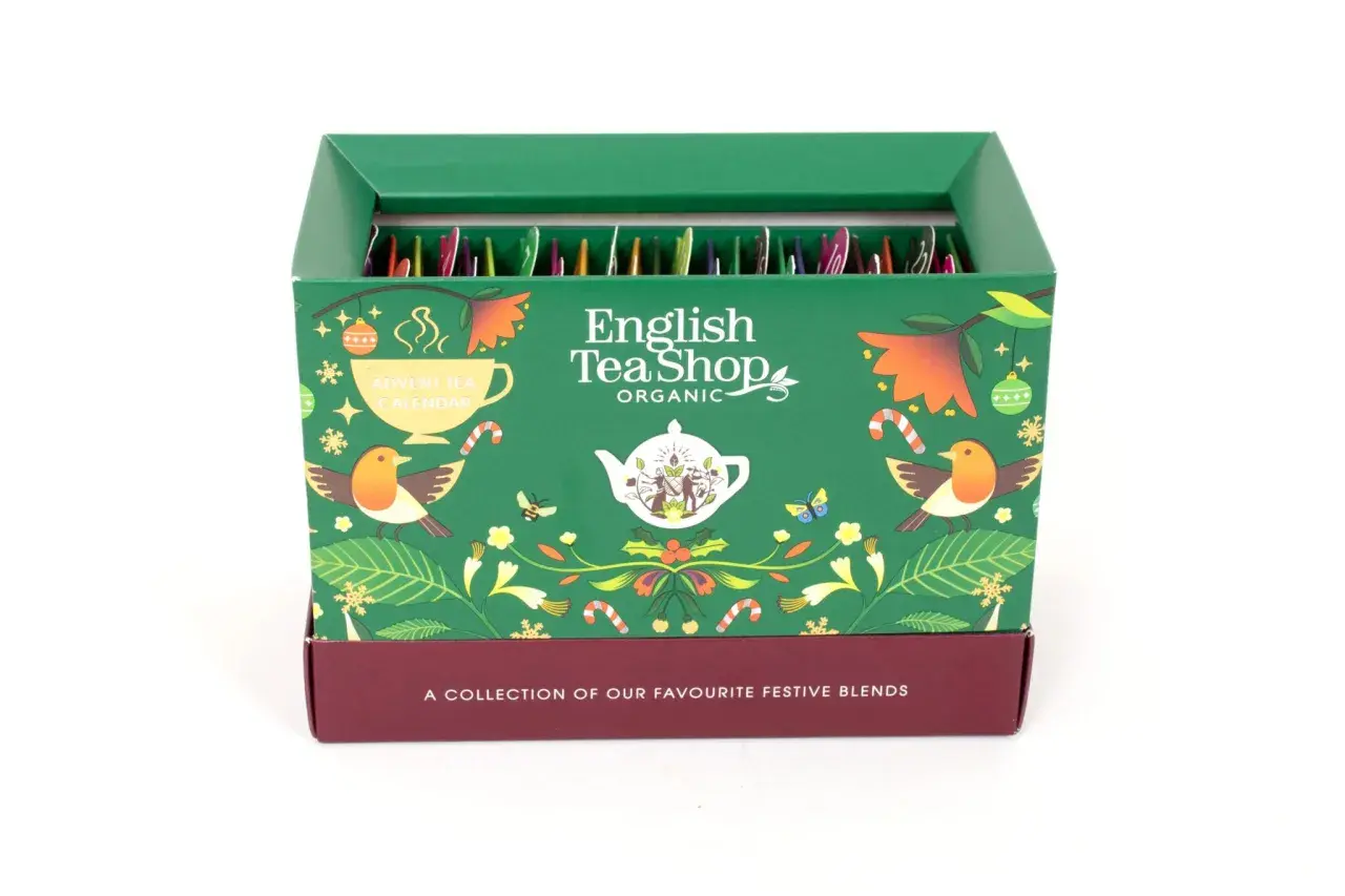 Zielony kalendarz adwentowy English Tea Shop z motywami świątecznymi, ptaszkami i liśćmi. W środku rzędy paczuszek z herbatą.