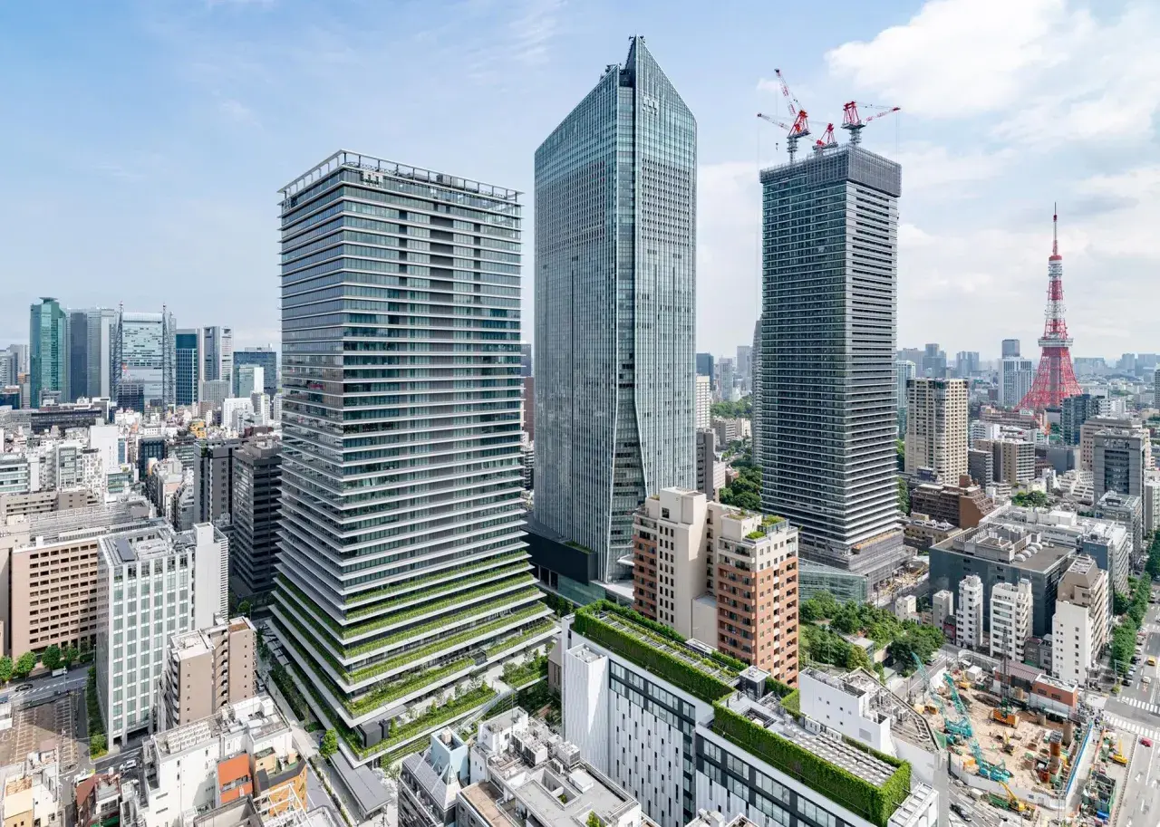 Nowoczesne wieżowce i Tokio Tower w Japonii. W tle widać plac budowy z dźwigami.