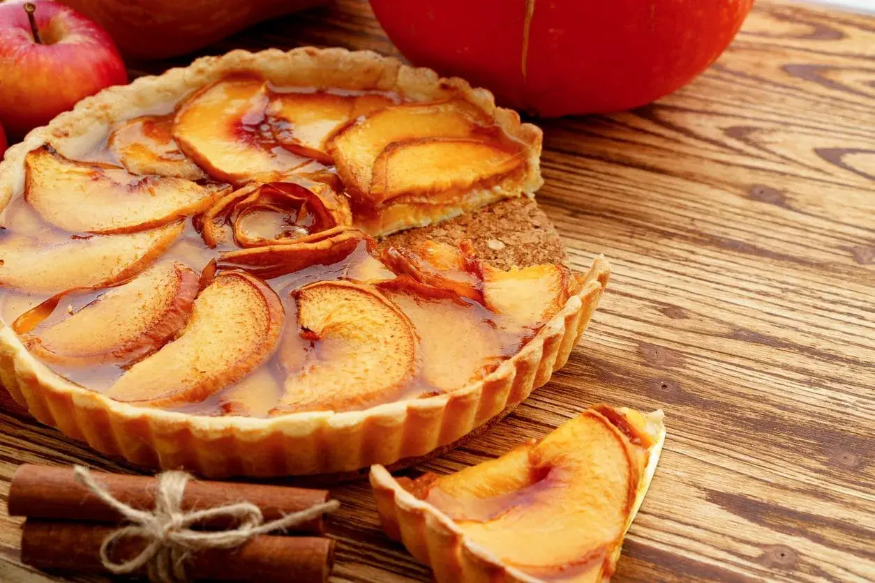Deliziosa crostata con mele caramellate e cannella, un classico tra i dolci con mele, pronta per essere gustata.