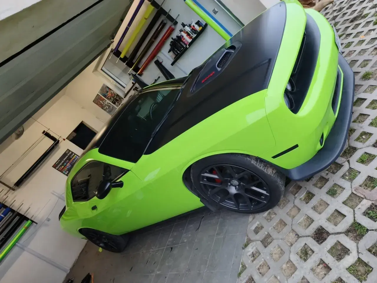Jasnozielony Dodge Challenger z czarną maską i dachem, gotowy do oklejenia. Zastanawiasz się, ile kosztuje oklejenie auta?