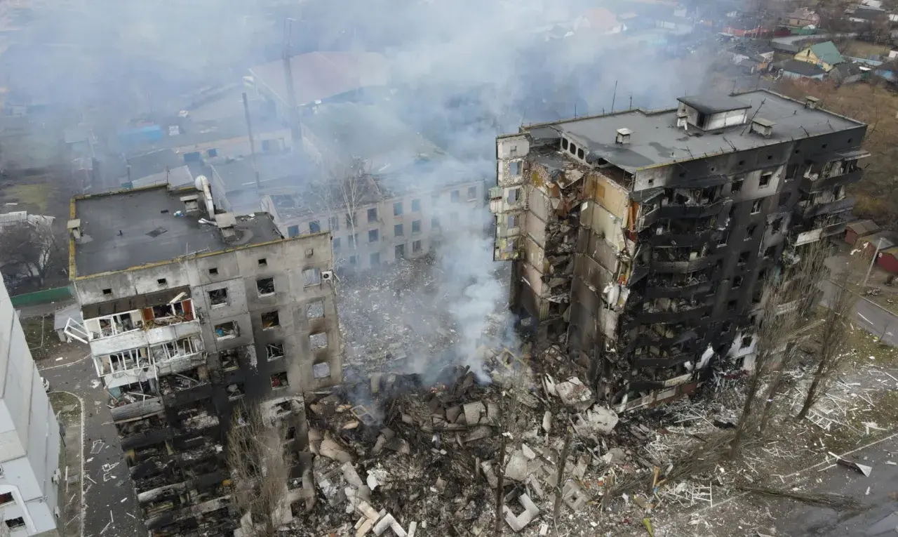 Zniszczone budynki mieszkalne, dym unoszący się nad gruzami, obraz tragedii, która rozpoczęła się, kiedy wybuchła wojna na Ukrainie.