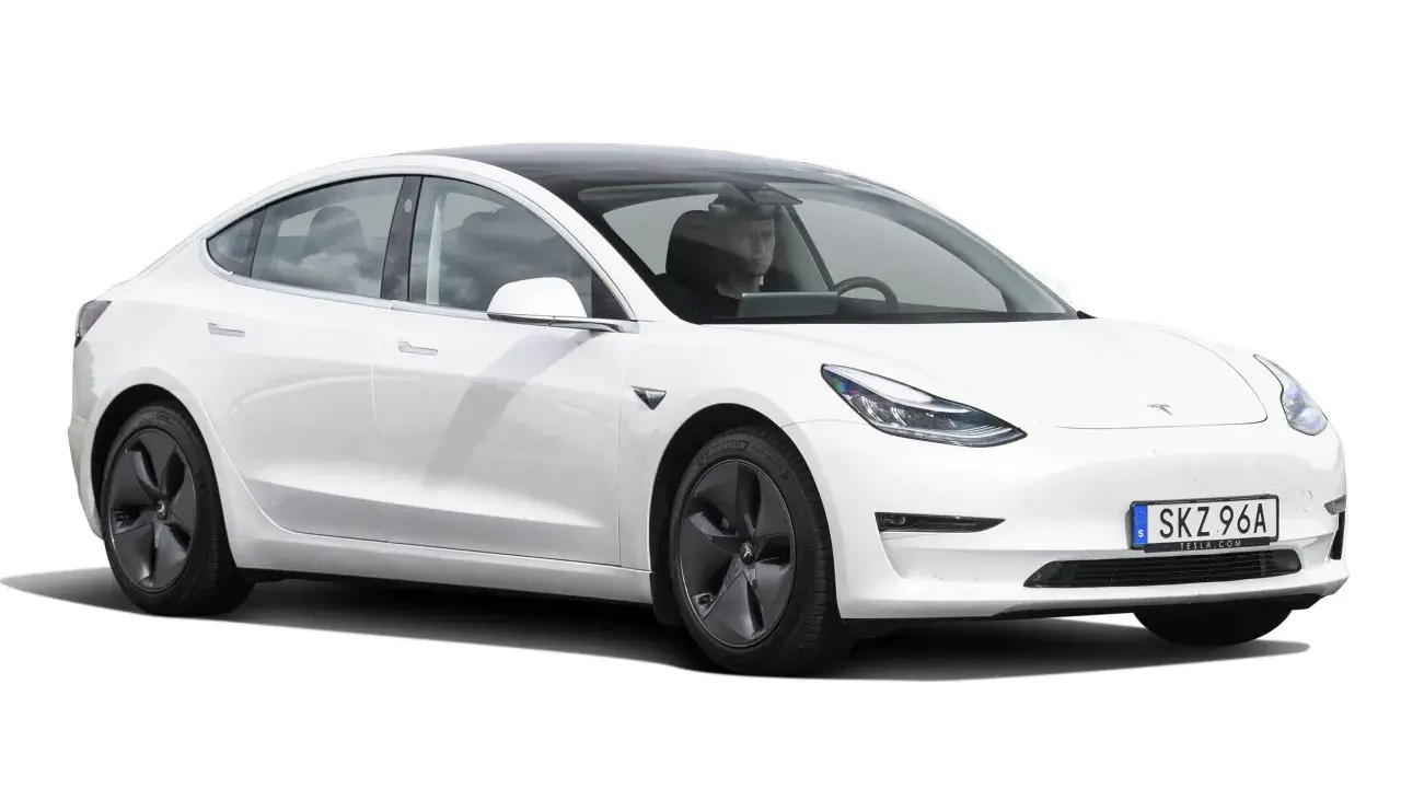 Vit Tesla Model 3 begagnad med förare. En elegant elbil redo för nya äventyr på svenska vägar.