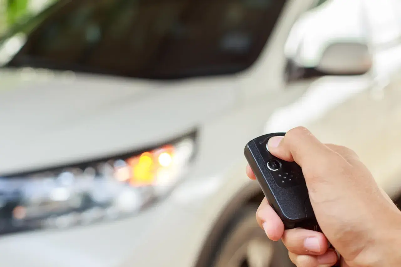 Dłoń trzyma kluczyk do samochodu, gotowa do uruchomienia silnika dzięki funkcji keyless go.