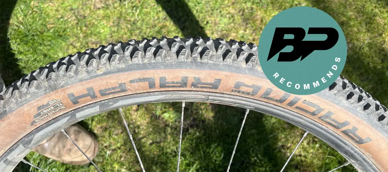 Close-up of a Schwalbe Racing Ralph tire on a bike wheel, ready for a review. The tan sidewall shows the "RALPH" branding.