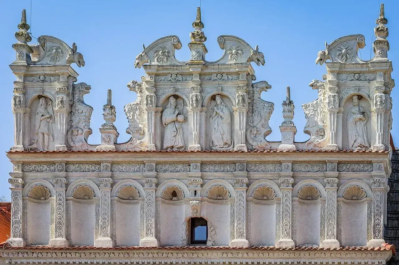Bogato zdobiona attyka z rzeźbami i ornamentami, przykład renesansowej architektury. Co to jest attyka? To nadbudowa nad głównym gzymsem budynku.