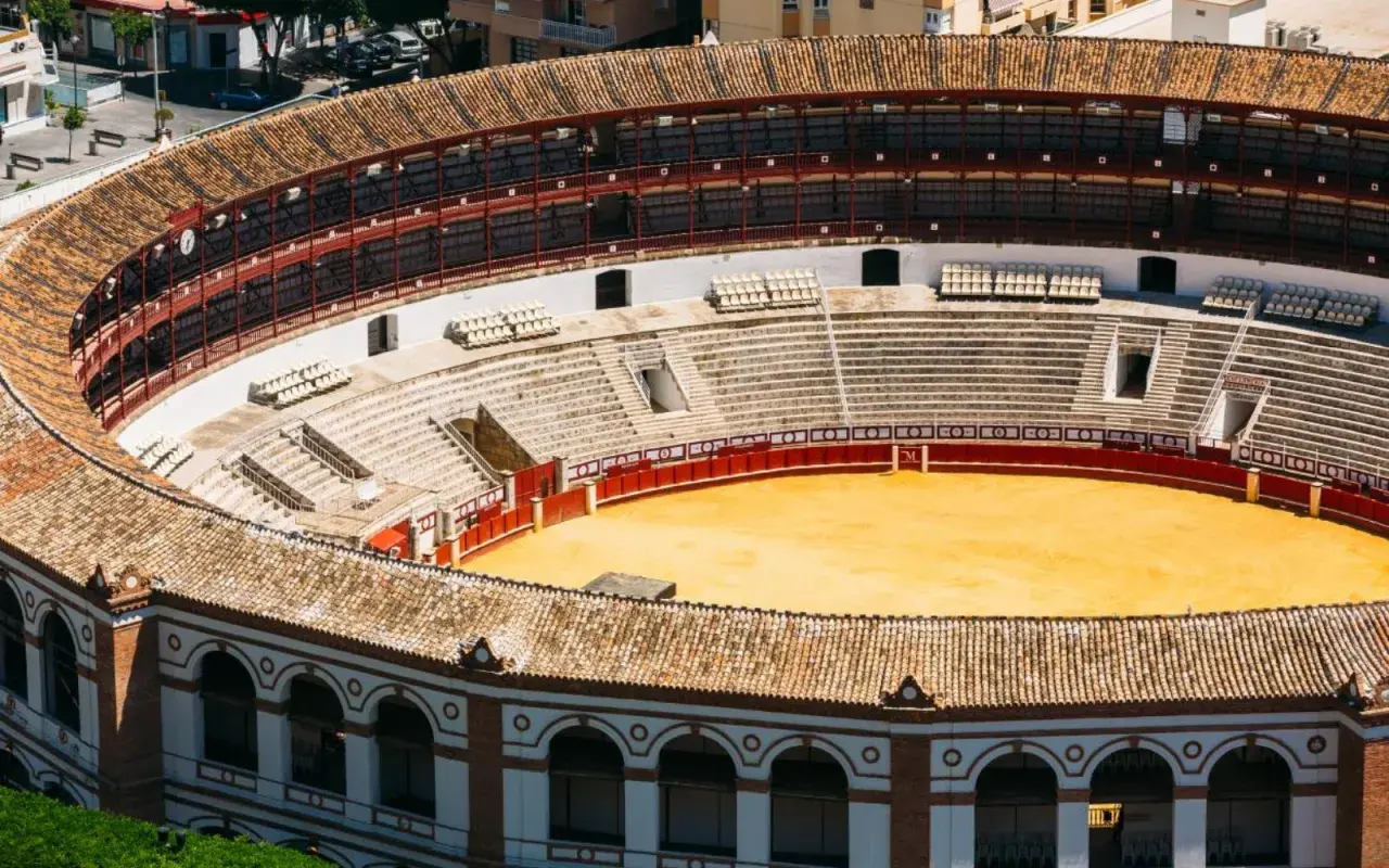 Vista aérea de la plaza de toros de Ronda, con sus gradas vacías y la arena dorada. El aforo de la plaza de toros de Ronda es impresionante.
