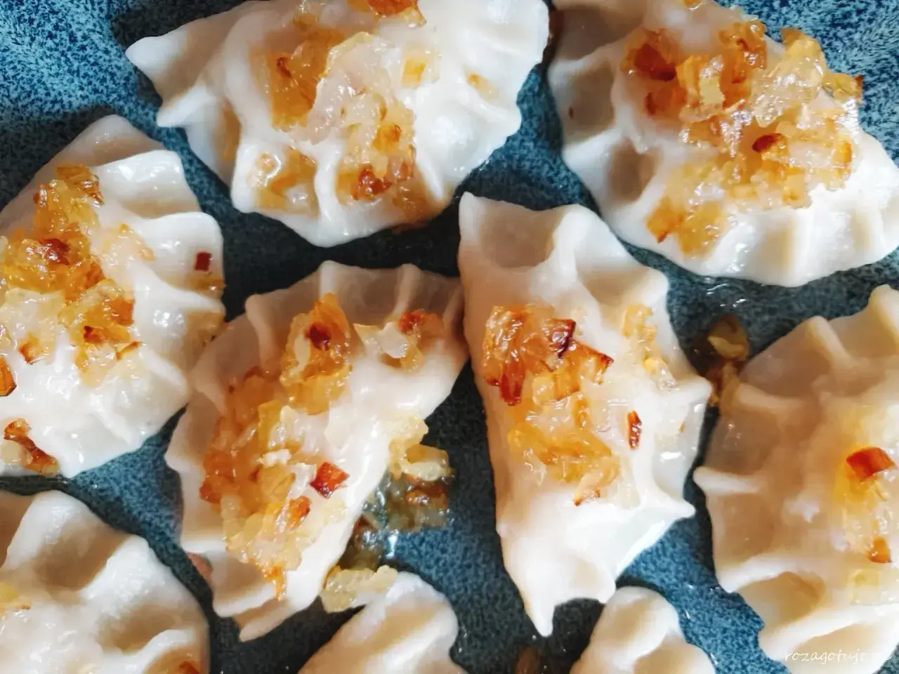 Pyszne pierogi z mięsa po rosole, posypane złocistą cebulką, kuszą swoim wyglądem i zapachem.