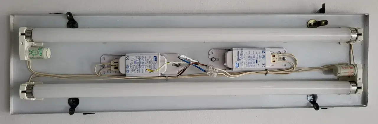 Dos tubos fluorescentes con balastros y arrancadores. Un tubo led g13 listo para iluminar.