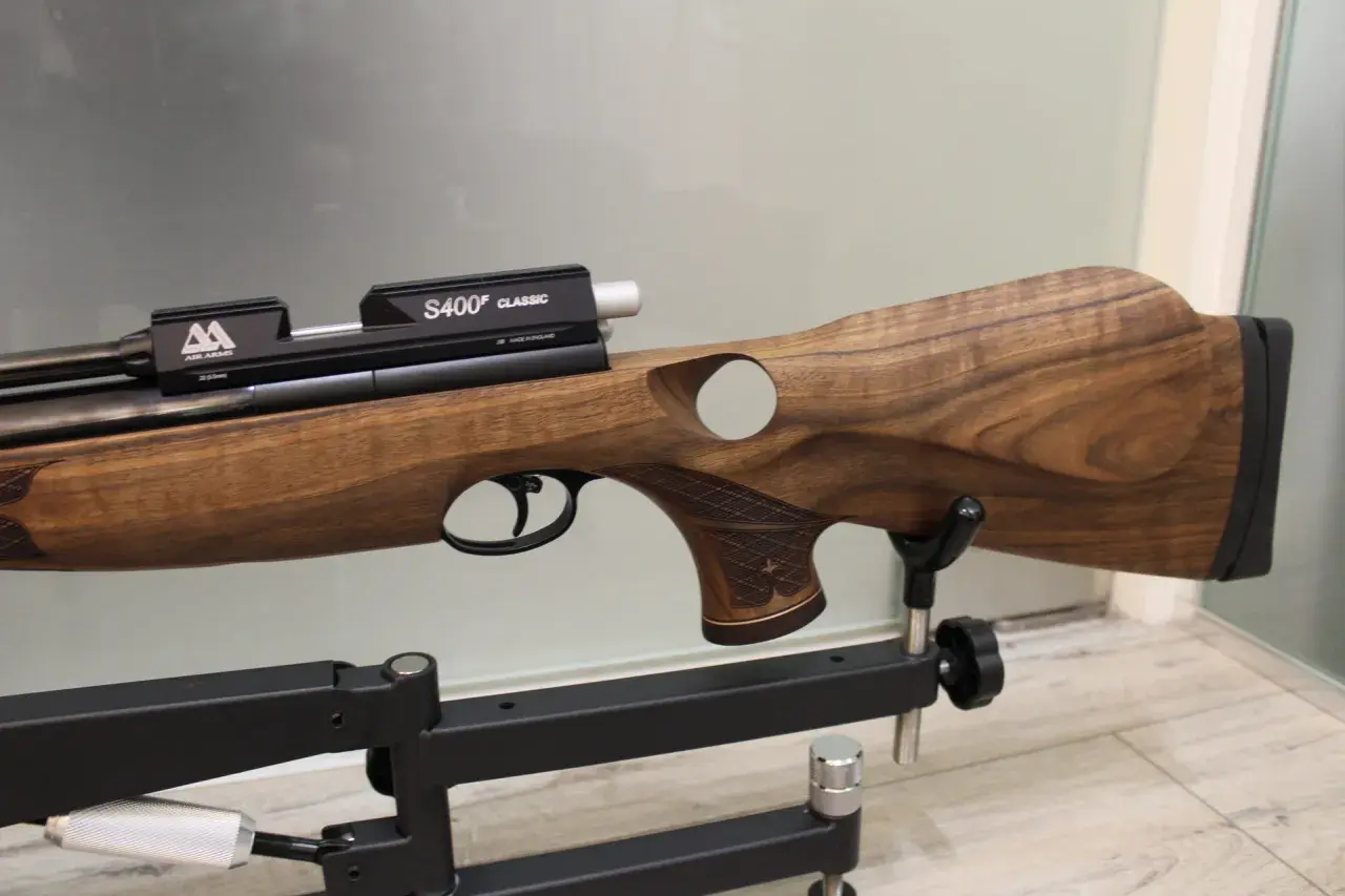 Elegancki karabin pneumatyczny Air Arms S510 z drewnianą osadą, prezentowany na statywie.