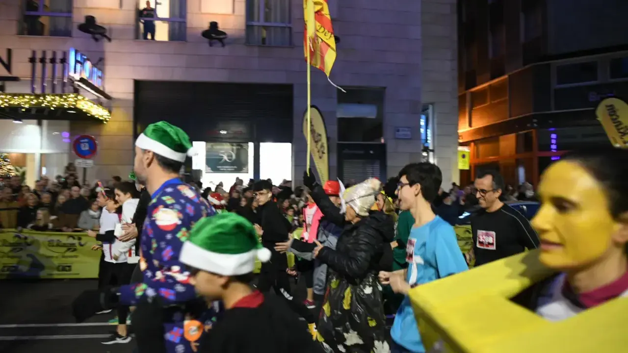 Participantes con gorros navideños y disfraces corren en el recorrido San Silvestre Zaragoza.