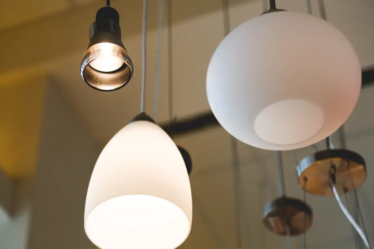 Varias lámparas cuelgan del techo, una con forma de lágrima y otra esférica, creando un ambiente acogedor con sus luces.
