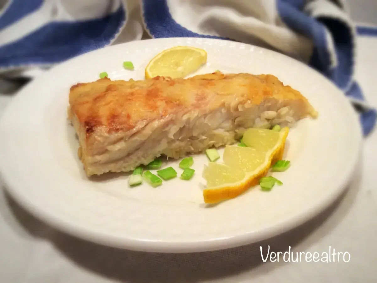 Un filetto di pesce persico cotto in padella, guarnito con spicchi di limone e erba cipollina. Perfetto per una ricetta pesce persico in padella al limone leggera e gustosa.