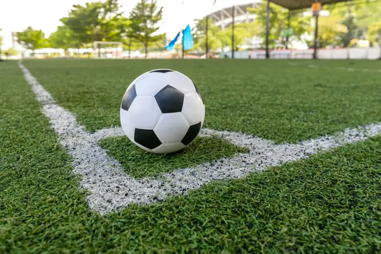 Piłka NFL leży na rogu boiska.