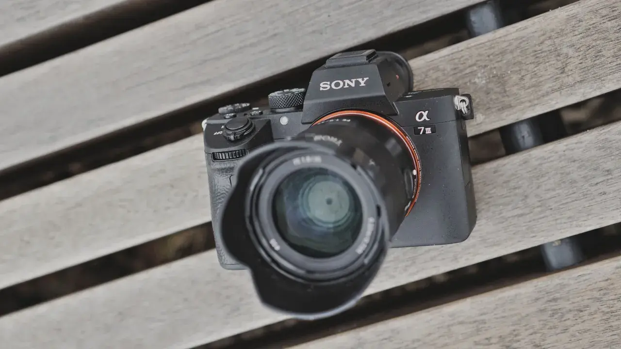 Sony A7 III test na drewnianej ławce. Aparat z obiektywem leży na deski.