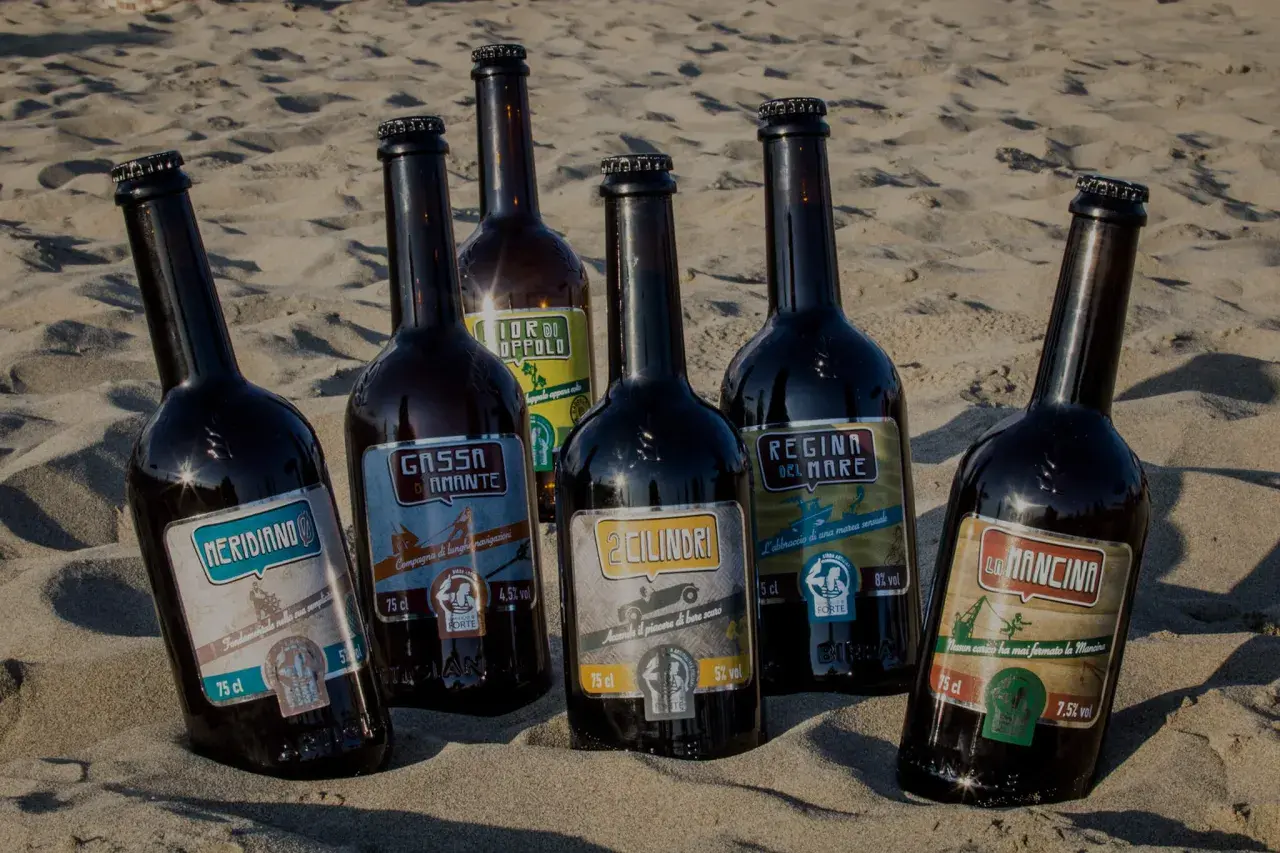 Sei bottiglie di birra del birrificio del forte sulla sabbia. Ogni etichetta racconta una storia: "Meridiano", "Gassa d'Amante", "2 Cilindri", "Regina del Mare", "La Mancina" e "Fior di Oppolo".