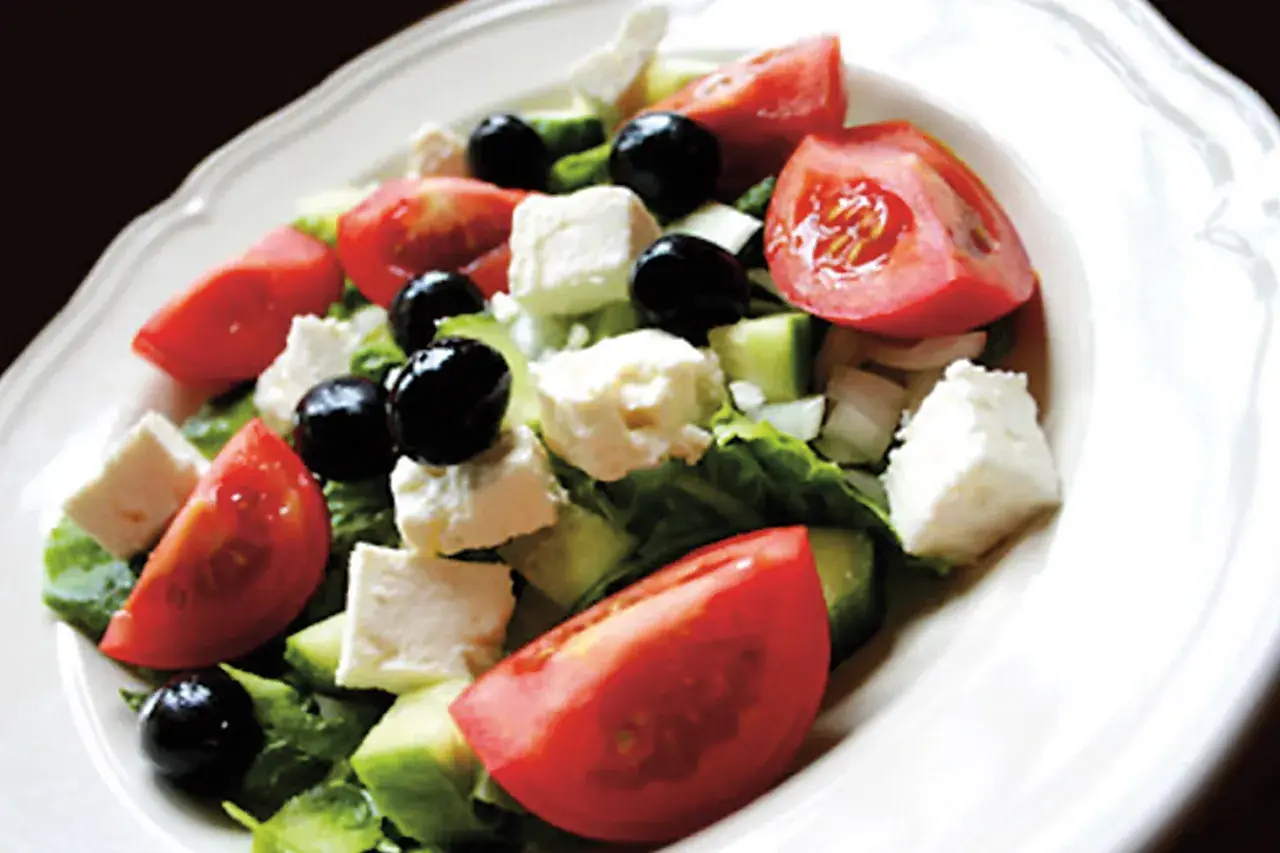 Insalata greca con pomodori, cetrioli, olive nere e cubetti di formaggio feta.