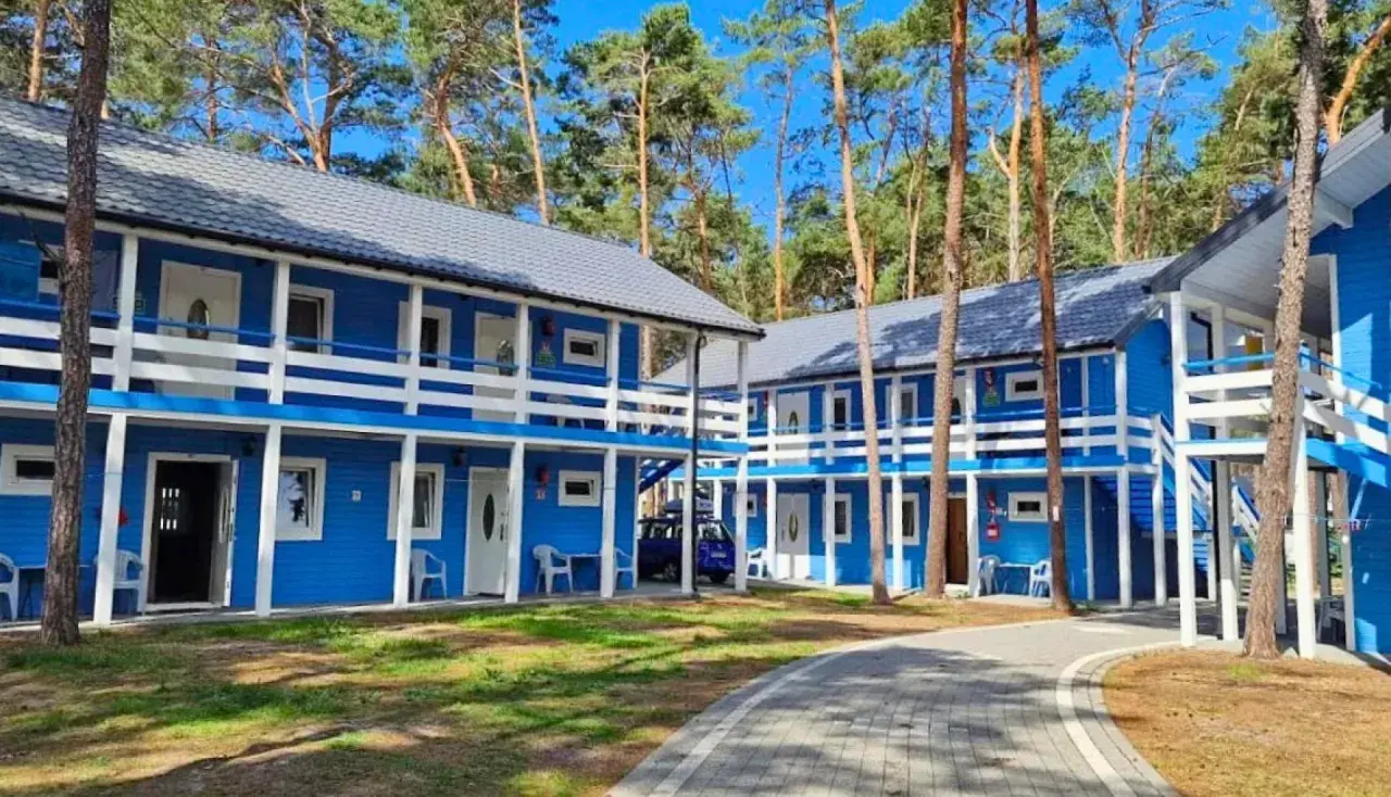 Niebieskie domki letniskowe w lesie, idealne na dziwnów noclegi blisko morza. Dostępne pokoje na parterze i piętrze z balkonami.
