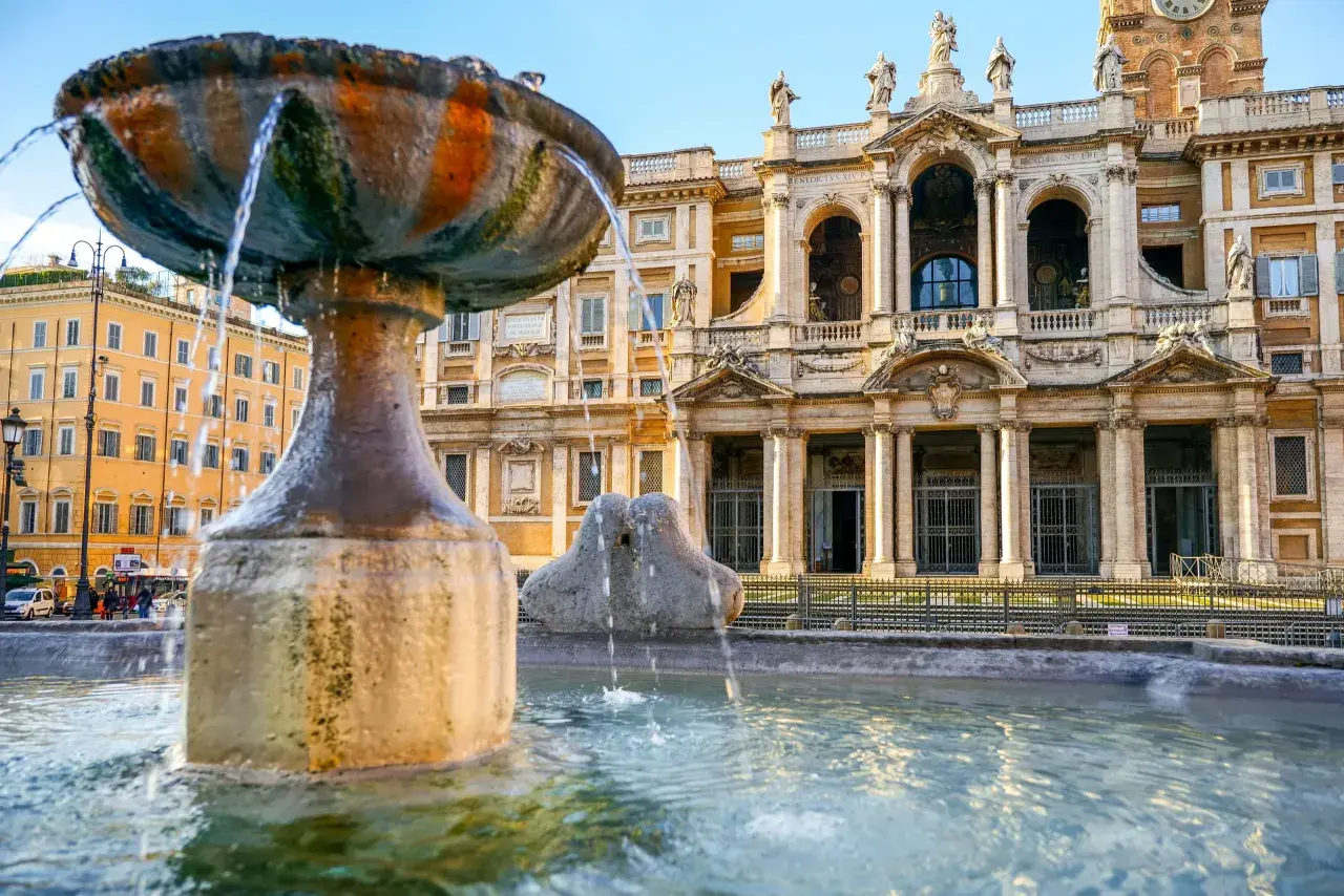 Fontana barocca davanti alla Basilica di Santa Maria Maggiore a Roma, con l'edificio imponente sullo sfondo.