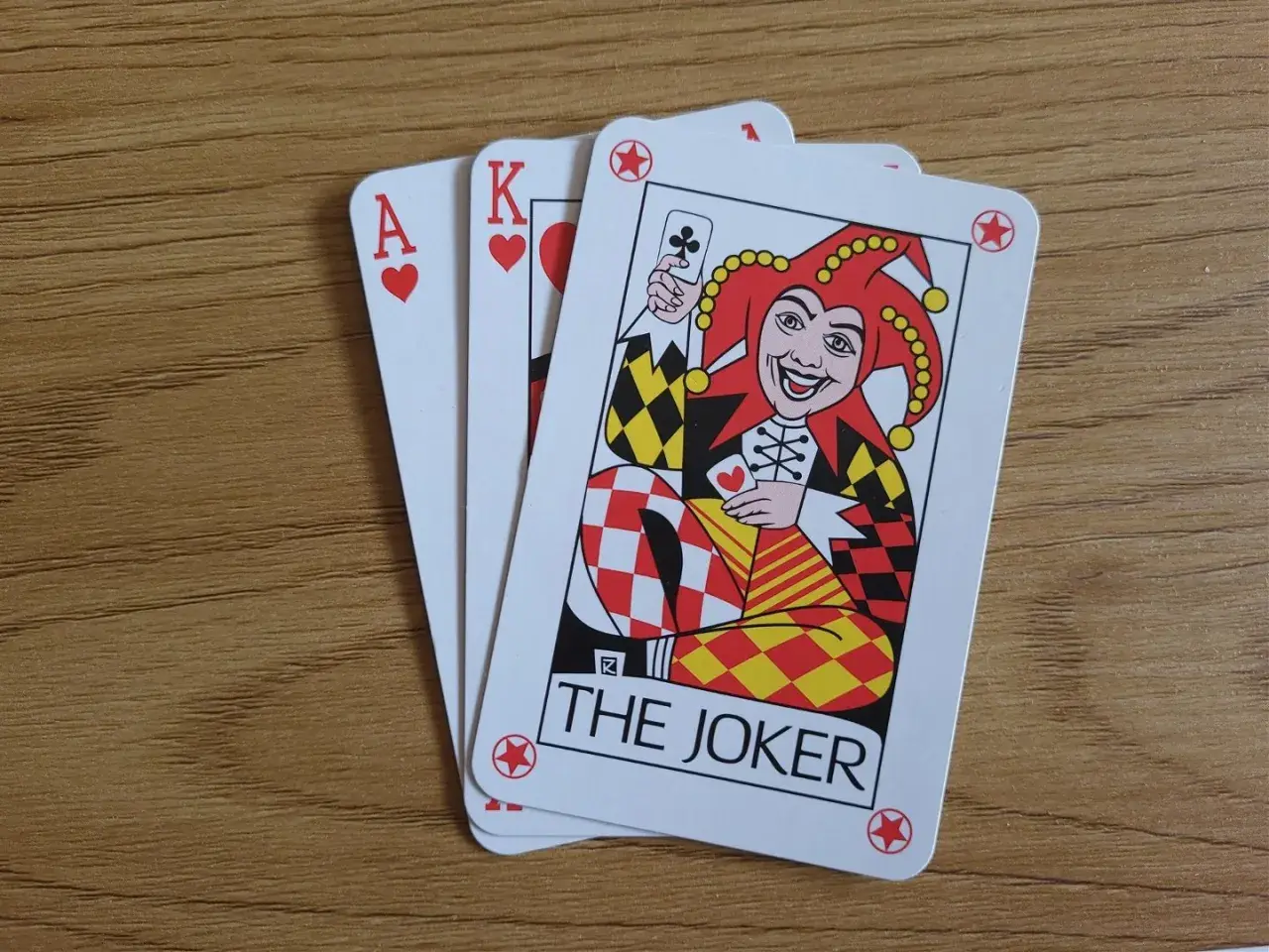 Karty do gry: as serce, król serce i joker. Idealne do nauki, jak się gra w remika.