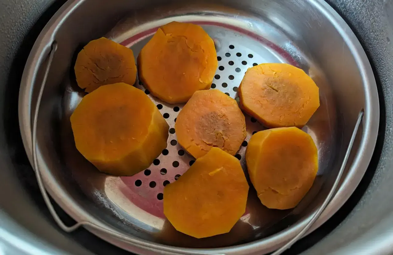 Morceaux de patates douces cuites à la vapeur dans un panier en métal, prêts pour une recette patate douce rapide.