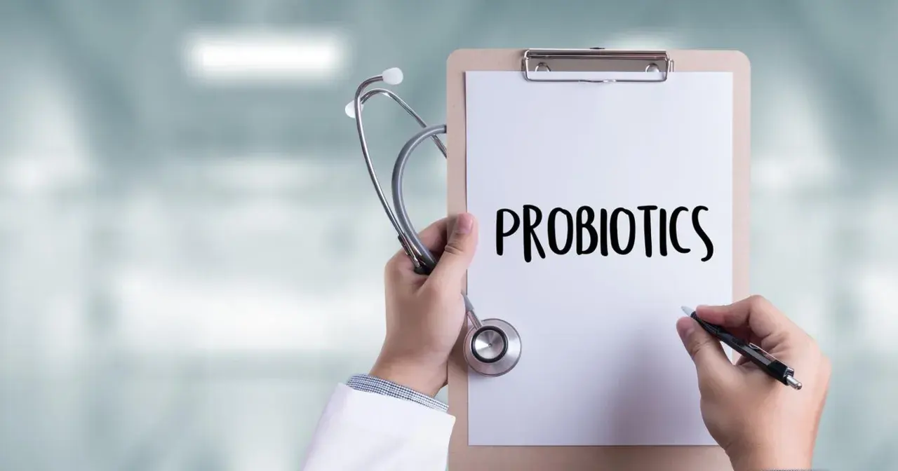 Lekarz trzyma stetoskop i notatnik z napisem "PROBIOTICS". Zastanawia się, do kiedy podawać probiotyk niemowlakowi.