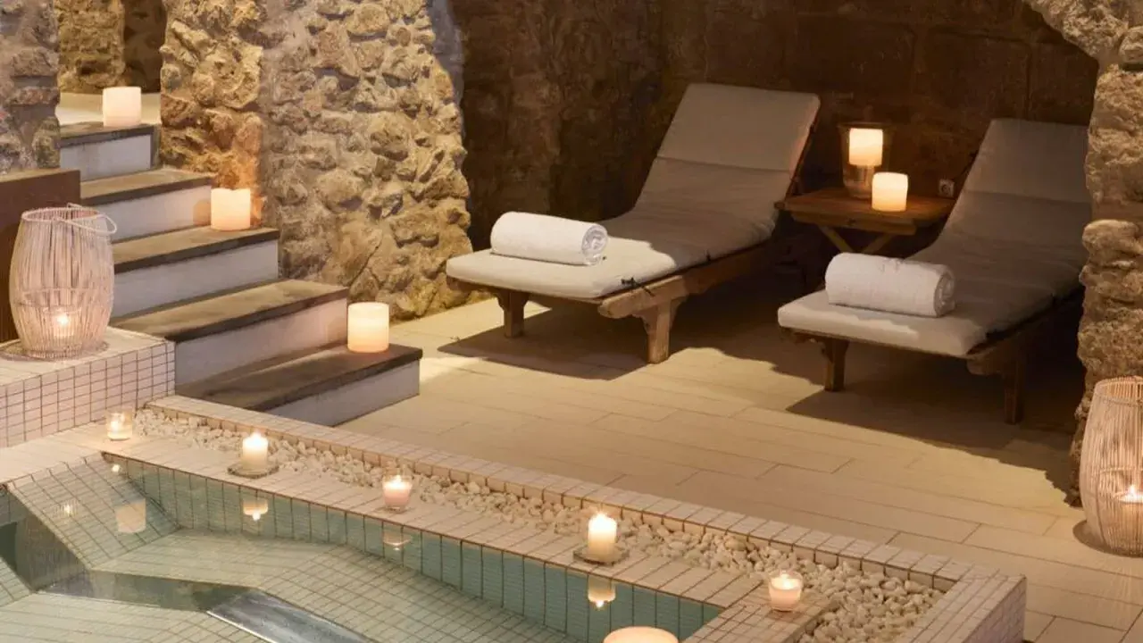 Relájate en este spa urbano con piscina, tumbonas y velas. Un oasis de paz y tranquilidad.