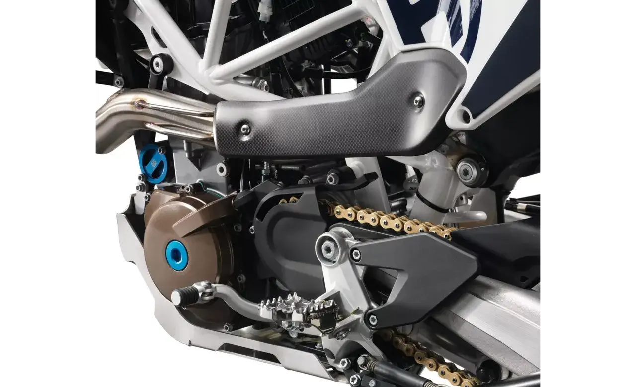 Szczegółowy widok silnika motocykla Husqvarna z widoczną złotą kasetą i elementami układu napędowego.