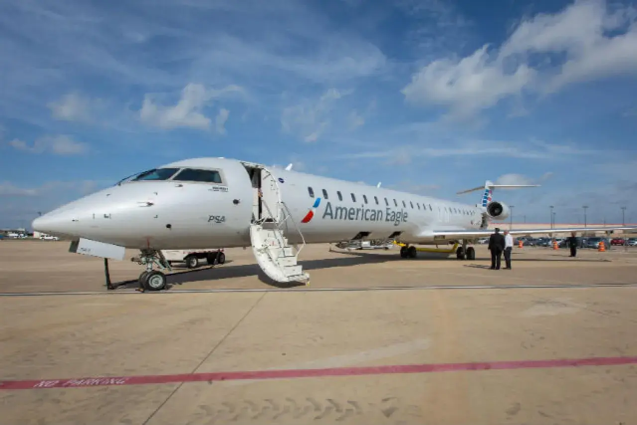 Samolot Canadair Regional Jet 900 linii American Eagle z otwartymi schodami na płycie lotniska.