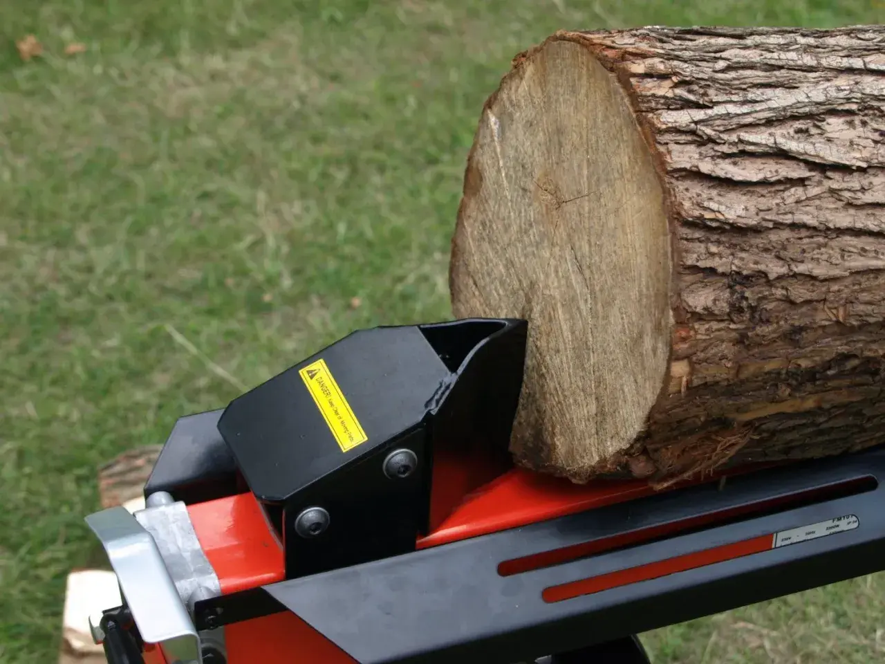 Ein Holzstamm wartet auf den benzin holzspalter, um ihn zu spalten.