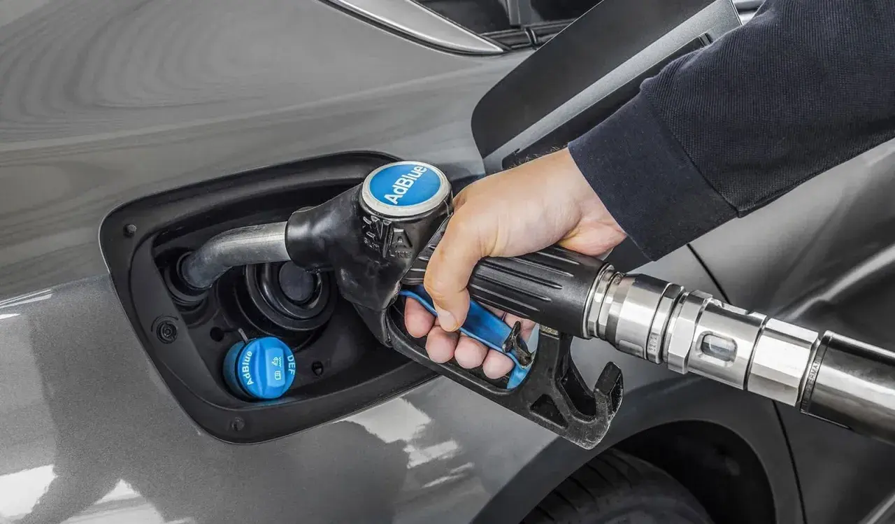 Persona repostando AdBlue en su coche. Averigua cuanto AdBlue consume un coche para optimizar tu viaje.