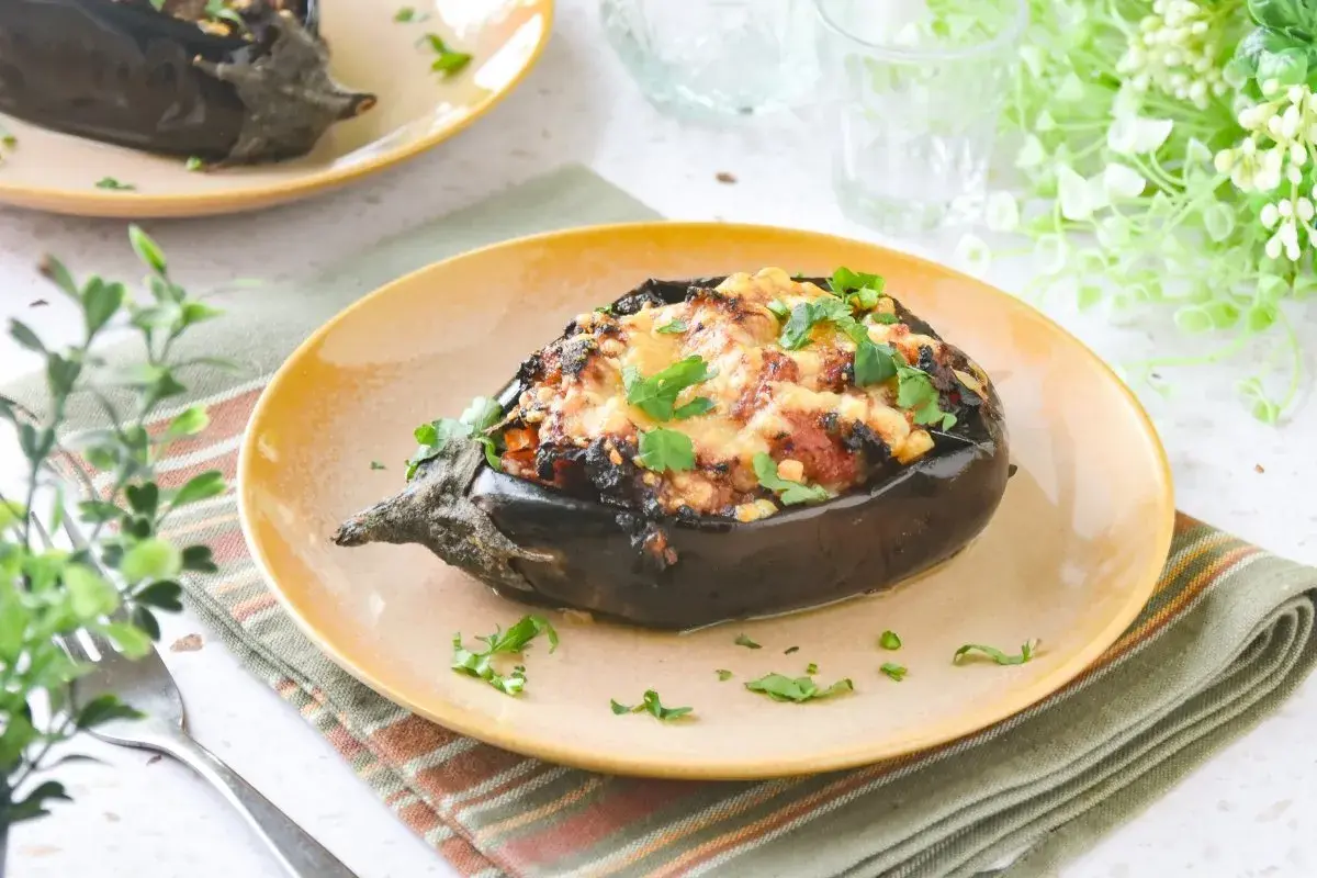 Berenjenas rellenas de carne picada, gratinadas y espolvoreadas con perejil fresco. Un plato casero y delicioso.