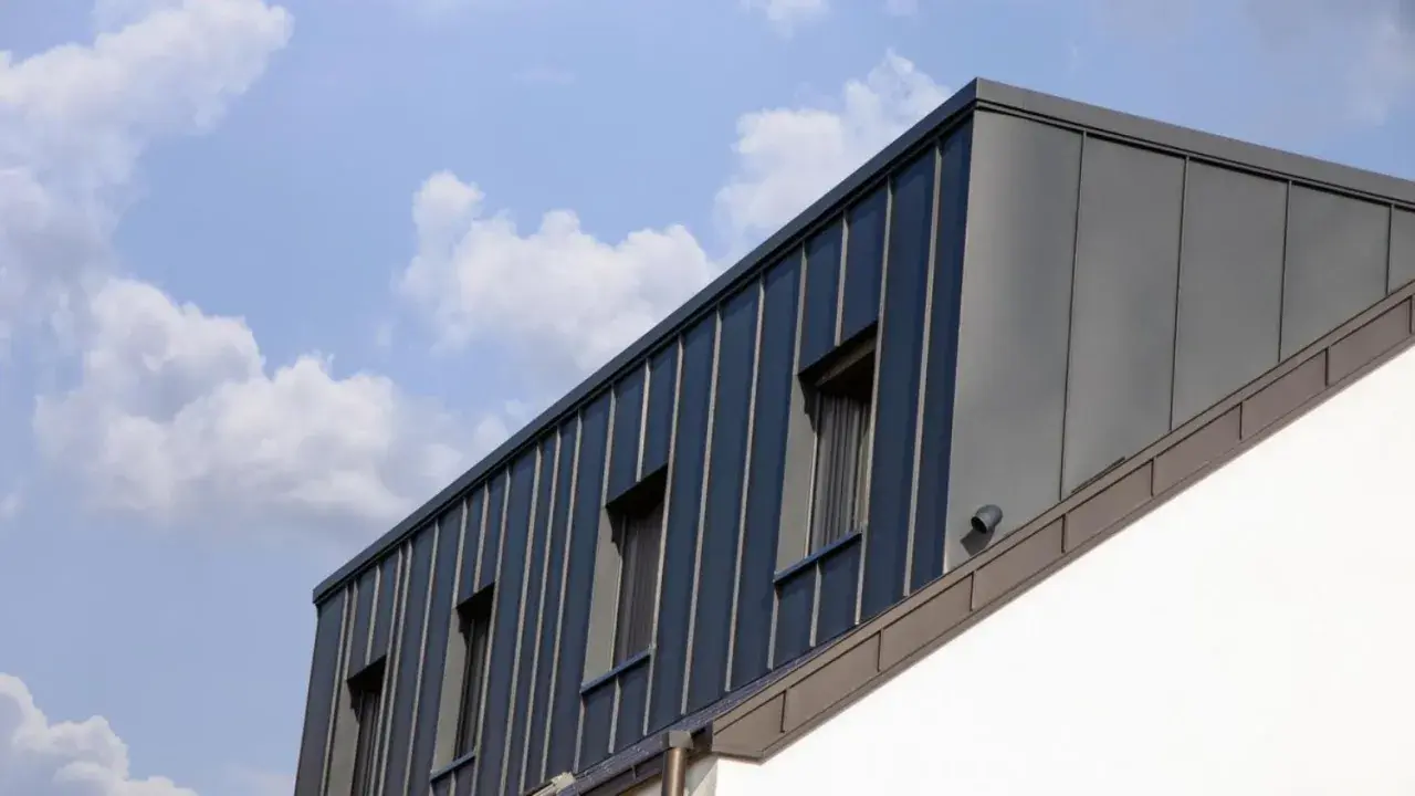 Moderne Dachgaube mit stehenden Blechbahnen und Fenstern. Informieren Sie sich über Dachgaube Kosten für Ihr Bauprojekt.