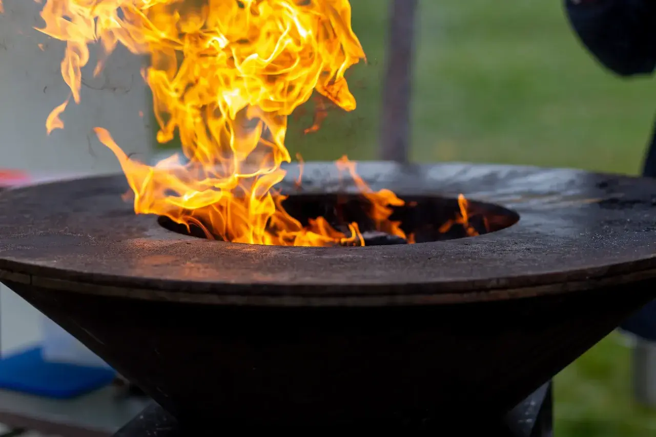 Flammes vives dans un brasero. Pensez à comment nettoyer un brasero après usage pour qu'il reste beau.