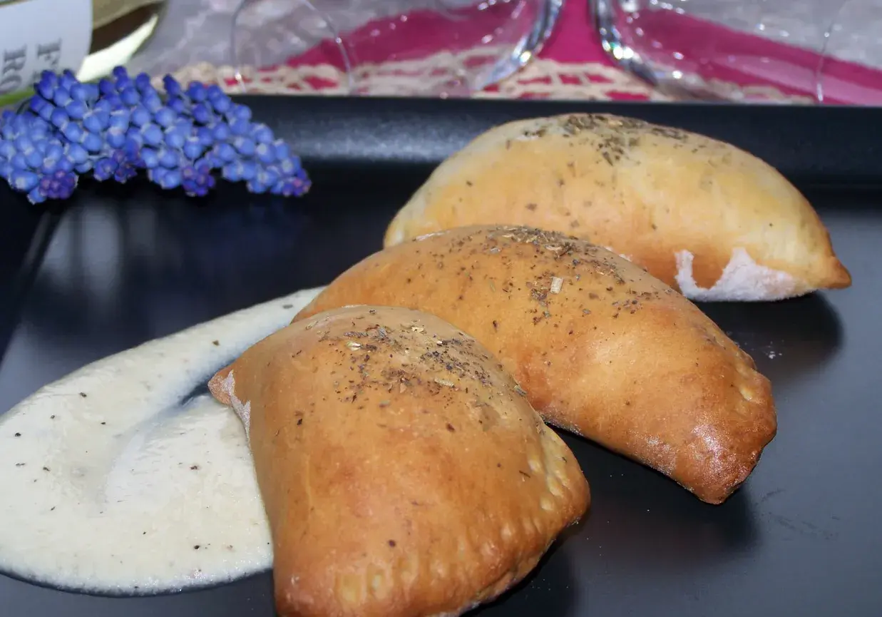 Pyszne pierożki z ciasta drożdżowego, posypane ziołami, podane z kremowym sosem. Idealne, gdy zastanawiasz się, co zrobić z drożdży.