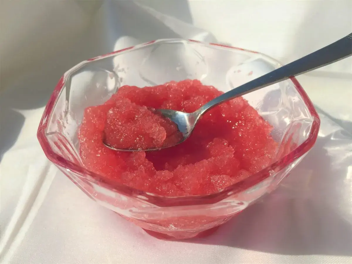 Sorbetto all'anguria senza gelatiera in una coppa di cristallo, pronto per essere gustato.