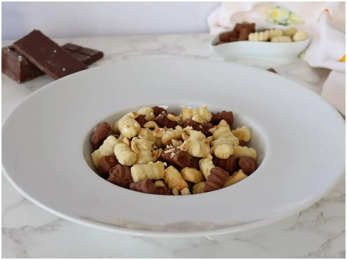 Gnocchi al cioccolato e nocciole, un dolce goloso in un piatto bianco.